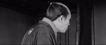 Movie still from “Sanjuro” (1962), directed by Akira Kurosawa – A black and white photo of a man's head; Close Up shot, Over the shoulder angle