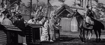 Movie still from “Sanjuro” (1962), directed by Akira Kurosawa – A black and white photo of a group of people standing outside; Wide shot, Low angle