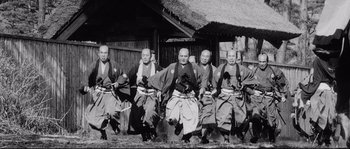 Movie still from “Sanjuro” (1962), directed by Akira Kurosawa – A black and white photo of a group of men in samurai garb; Wide shot, Low angle