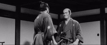 Movie still from “Sanjuro” (1962), directed by Akira Kurosawa – A man and a woman in traditional japanese garb; Medium shot, Over the shoulder angle