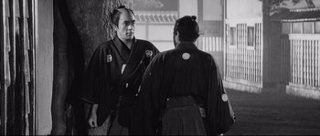 Movie still from “Sanjuro” (1962), directed by Akira Kurosawa – Two men in traditional japanese garb looking at each other; Medium shot, Over the shoulder angle
