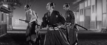 Movie still from “Sanjuro” (1962), directed by Akira Kurosawa – A group of men standing next to each other holding swords; Medium shot, Low angle