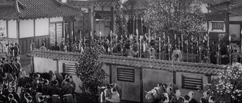 Movie still from “Sanjuro” (1962), directed by Akira Kurosawa – A group of people standing next to each other on top of a fence; Extreme Wide shot, High angle