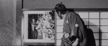 Movie still from “Sanjuro” (1962), directed by Akira Kurosawa – A black and white photo of a man holding a sword; Medium shot, Low angle