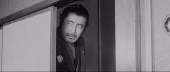 Movie still from “Sanjuro” (1962), directed by Akira Kurosawa – Black and white photograph of a man looking out a window; Close Up shot, Low angle