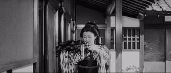 Movie still from “Sanjuro” (1962), directed by Akira Kurosawa – An old photo of a geisha holding a tea pot; Medium shot, Low angle