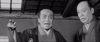 Movie still from “Sanjuro” (1962), directed by Akira Kurosawa – An older man with a surprised look on his face; Medium shot, Low angle