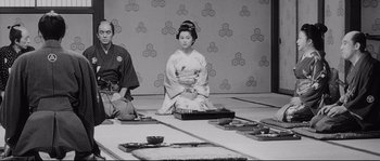 Movie still from “Sanjuro” (1962), directed by Akira Kurosawa – A woman sitting on the ground in front of another woman; Wide shot, Low angle