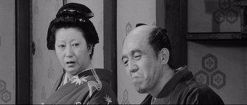 Movie still from “Sanjuro” (1962), directed by Akira Kurosawa – An older man and a younger woman in traditional japanese garb; Medium shot, Over the shoulder angle