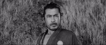 Movie still from “Sanjuro” (1962), directed by Akira Kurosawa – Black and white photograph of a man in a kimono; Close Up shot, Low angle