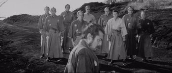 Movie still from “Sanjuro” (1962), directed by Akira Kurosawa – A group of men standing in front of each other; Medium shot, Low angle