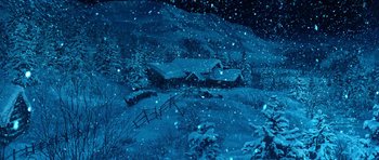 Movie still from “Santa Claus” (1985), directed by Jeannot Szwarc – A snowy night scene with a house and a fence; Extreme Wide shot, High angle