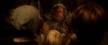 Movie still from “Santa Claus” (1985), directed by Jeannot Szwarc – A man with a long beard is looking into a mirror; Close Up shot, Over the shoulder angle