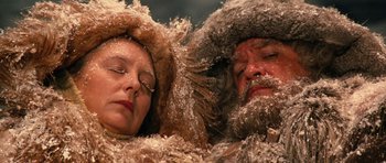 Movie still from “Santa Claus” (1985), directed by Jeannot Szwarc – A man and a woman in fur coats and fur hats; Close Up shot, Low angle