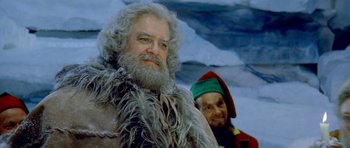 Movie still from “Santa Claus” (1985), directed by Jeannot Szwarc – A man with a long beard and a man with a long beard and a hat; Close Up shot, Low angle