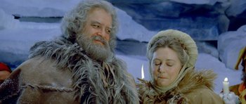 Movie still from “Santa Claus” (1985), directed by Jeannot Szwarc – A man and a woman dressed in fur and fur clothing; Close Up shot, Low angle