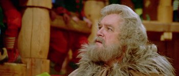 Movie still from “Santa Claus” (1985), directed by Jeannot Szwarc – An old man with a beard and a long beard; Close Up shot, Low angle