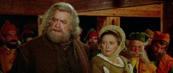 Movie still from “Santa Claus” (1985), directed by Jeannot Szwarc – A man and a woman standing next to each other; Close Up shot, Over the shoulder angle