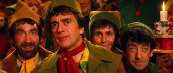 Movie still from “Santa Claus” (1985), directed by Jeannot Szwarc – A man and a woman dressed in green and yellow; Close Up shot, Low angle