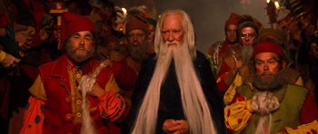 Movie still from “Santa Claus” (1985), directed by Jeannot Szwarc – An old man with long white hair and a long white beard; Medium shot, Low angle