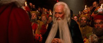 Movie still from “Santa Claus” (1985), directed by Jeannot Szwarc – A group of people dressed up in costumes; Close Up shot, Over the shoulder angle