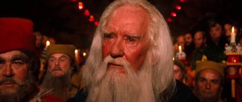Movie still from “Santa Claus” (1985), directed by Jeannot Szwarc – An old man with long white hair and a long beard; Close Up shot, Low angle