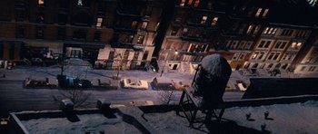 Movie still from “Santa Claus” (1985), directed by Jeannot Szwarc – A snowy night in a city with buildings lit up in the background; Extreme Wide shot, High angle