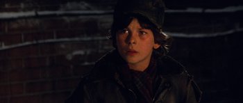 Movie still from “Santa Claus” (1985), directed by Jeannot Szwarc – A young boy wearing a hat and a jacket; Close Up shot, Over the shoulder angle