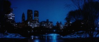 Movie still from “Santa Claus” (1985), directed by Jeannot Szwarc – A view of a city at night from across a river; Extreme Wide shot, High angle