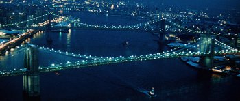 Movie still from “Santa Claus” (1985), directed by Jeannot Szwarc – A view of a bridge lit up at night from above; Extreme Wide shot, High angle