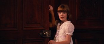Movie still from “Santa Claus” (1985), directed by Jeannot Szwarc – A young girl standing in front of an open door; Close Up shot, High angle