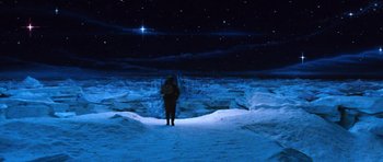 Movie still from “Santa Claus” (1985), directed by Jeannot Szwarc – A person standing in the middle of a snow covered field; Extreme Wide shot, High angle