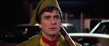 Movie still from “Santa Claus” (1985), directed by Jeannot Szwarc – A person holding a wooden stick; Close Up shot, Low angle