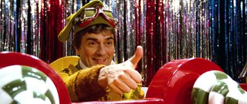 Movie still from “Santa Claus” (1985), directed by Jeannot Szwarc – A man giving a thumbs up while sitting in a fire hydrant; Close Up shot, Low angle