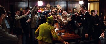 Movie still from “Santa Claus” (1985), directed by Jeannot Szwarc – A group of people gathered around a table; Wide shot, Over the shoulder angle