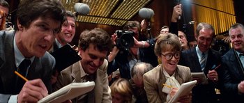 Movie still from “Santa Claus” (1985), directed by Jeannot Szwarc – A group of people gathered in a large room; Medium shot, Overhead angle
