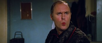 Movie still from “Santa Claus” (1985), directed by Jeannot Szwarc – A person wearing a suit and tie; Close Up shot, Over the shoulder angle