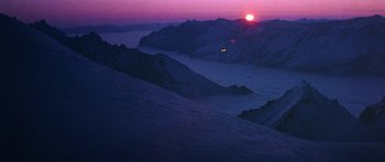 Movie still from “Santa Claus” (1985), directed by Jeannot Szwarc – The sun is setting over the mountains in the distance; Extreme Wide shot, High angle