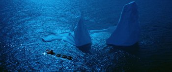 Movie still from “Santa Claus” (1985), directed by Jeannot Szwarc – A couple of white swans floating on top of a body of water; Extreme Wide shot, High angle