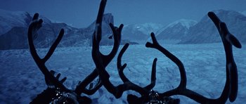 Movie still from “Santa Claus” (1985), directed by Jeannot Szwarc – A view of a snowy mountain range from the top of a mountain; Extreme Wide shot, Overhead angle