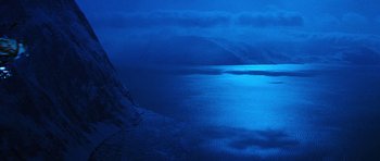 Movie still from “Santa Claus” (1985), directed by Jeannot Szwarc – A body of water at night with a mountain in the background; Extreme Wide shot, High angle