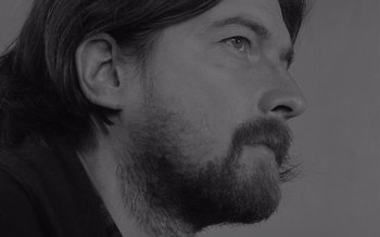 Movie still from “Satantango” (1994), directed by Béla Tarr – Black and white photograph of a man with a beard; Close Up shot, Low angle