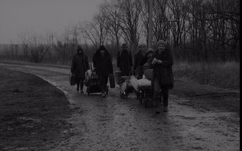 Movie still from “Satantango” (1994), directed by Béla Tarr – A black and white photo of a group of people walking down a road; Wide shot, High angle