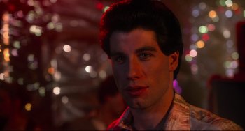 Movie still from “Saturday Night Fever” (1977), directed by John Badham – A person wearing a shirt; Close Up shot, Low angle
