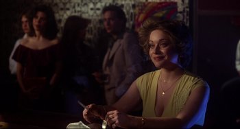 Movie still from “Saturday Night Fever” (1977), directed by John Badham – A woman sitting at a table smoking a cigarette; Close Up shot, Over the shoulder angle