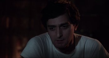 Movie still from “Saturday Night Fever” (1977), directed by John Badham – A person wearing a white t - shirt; Close Up shot, Low angle