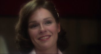 Movie still from “Saturday Night Fever” (1977), directed by John Badham – A woman smiling for the camera; Close Up shot, Over the shoulder angle