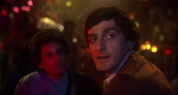 Movie still from “Saturday Night Fever” (1977), directed by John Badham – Two men are standing in a dark room; Close Up shot, Low angle