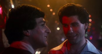 Movie still from “Saturday Night Fever” (1977), directed by John Badham – A couple of men standing next to each other; Close Up shot, Over the shoulder angle
