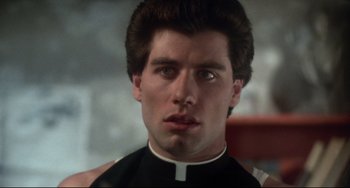Movie still from “Saturday Night Fever” (1977), directed by John Badham – A man in a priest's outfit looking at the camera; Close Up shot, Low angle